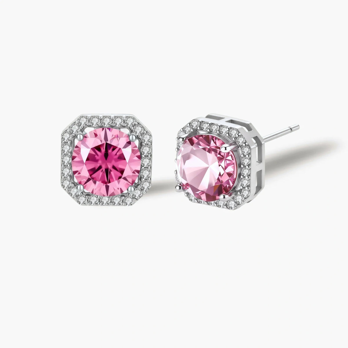 Pink moissanite studs in octagonal sterling silver halo settings with sparkling accent stones on cream background.