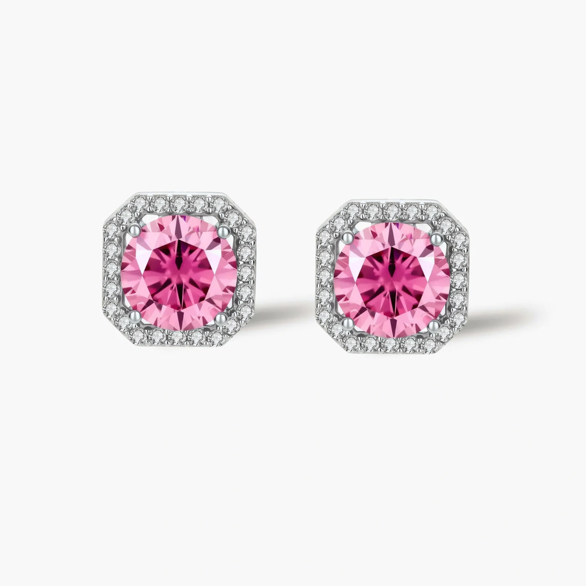 Pink moissanite studs in octagonal sterling silver halo settings with sparkling accent stones on cream background.