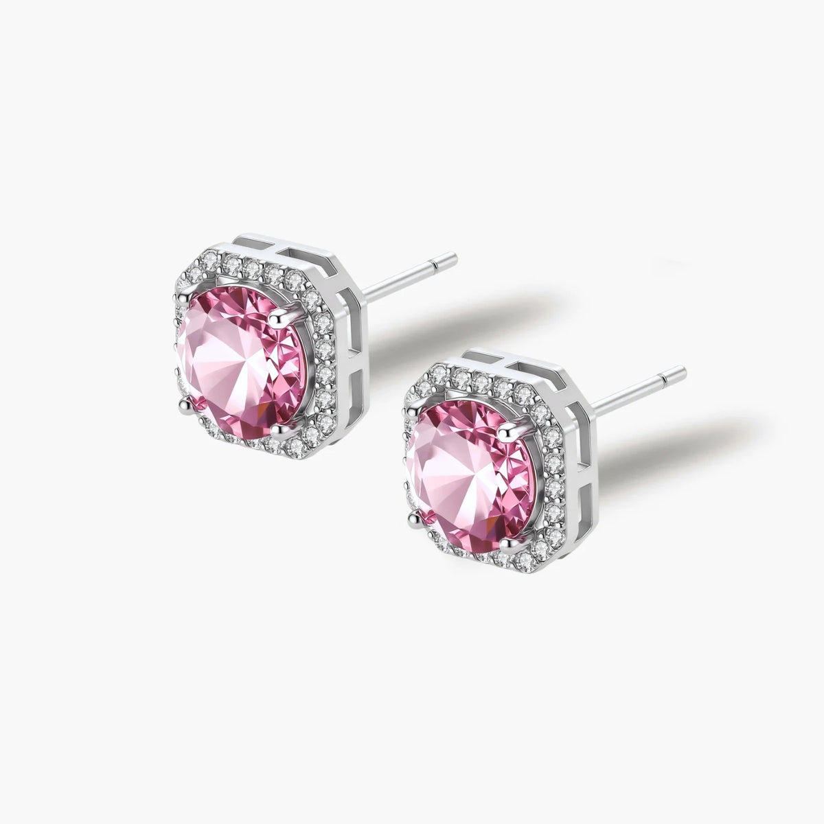 Pink moissanite studs in octagonal sterling silver halo settings with sparkling accent stones on cream background.