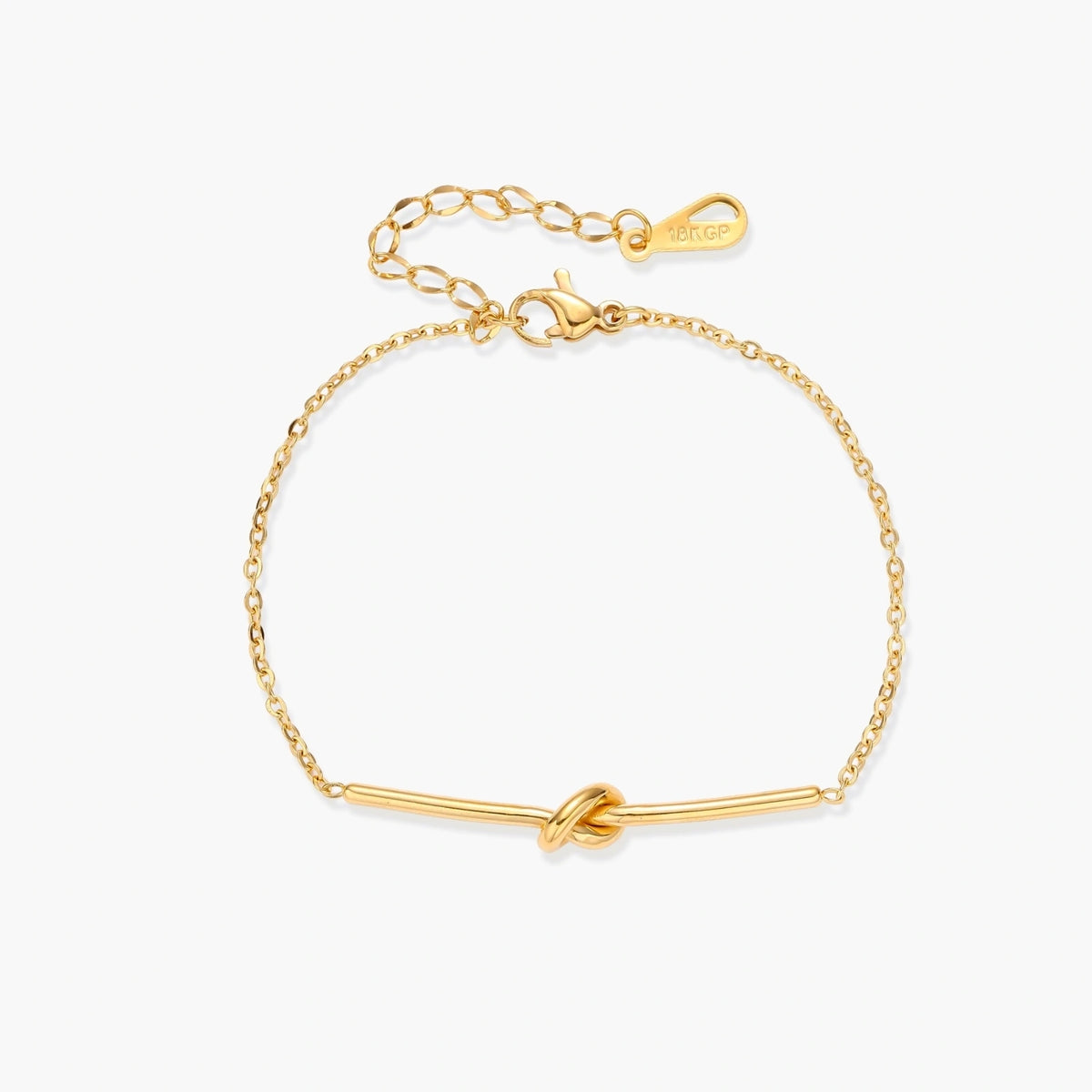 Delicate gold chain bracelet with minimalist bar and centered knot detail on cream background