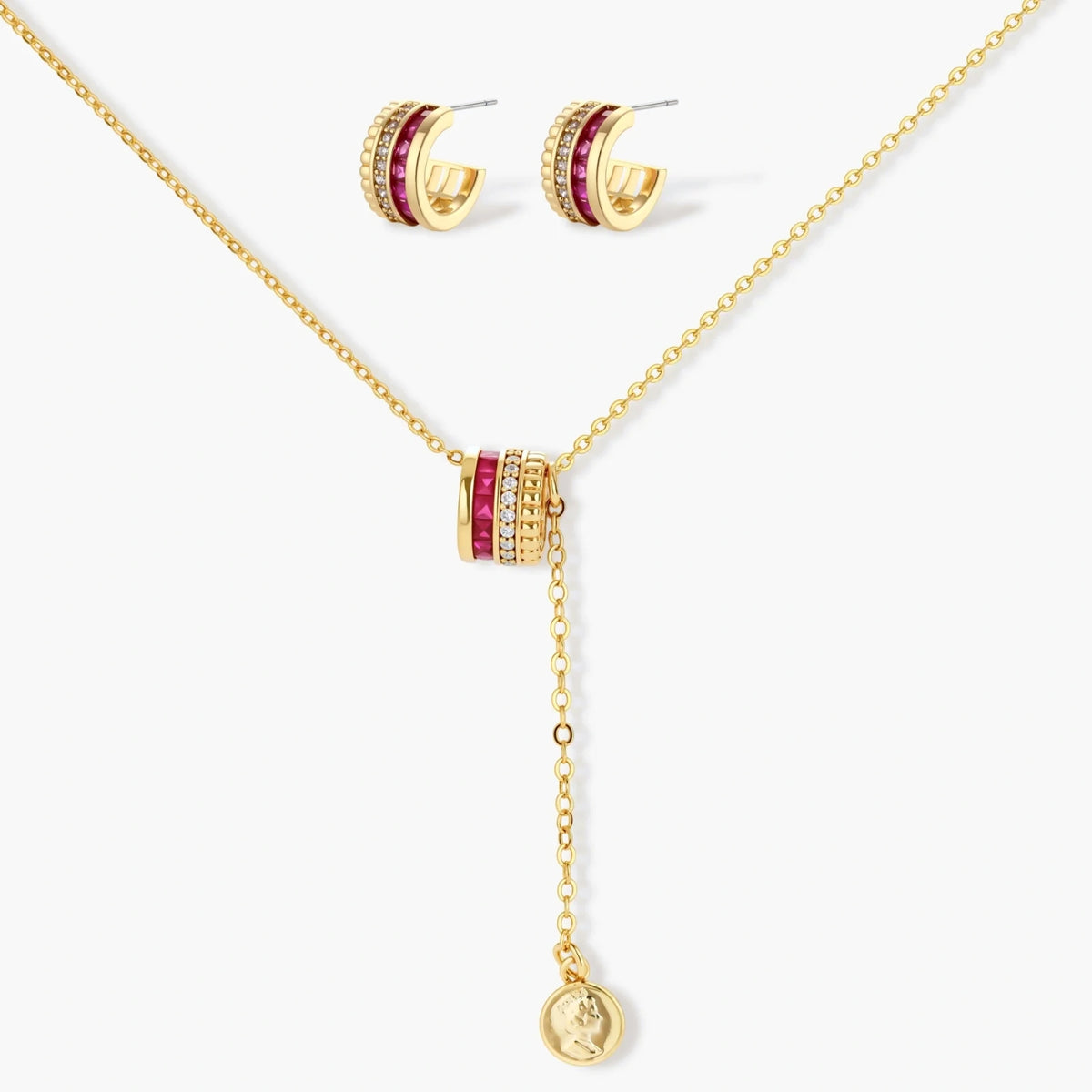 Three-piece jewelry set featuring 14K gold plated pieces with deep red cubic zirconia stones and clear crystals on cream background.